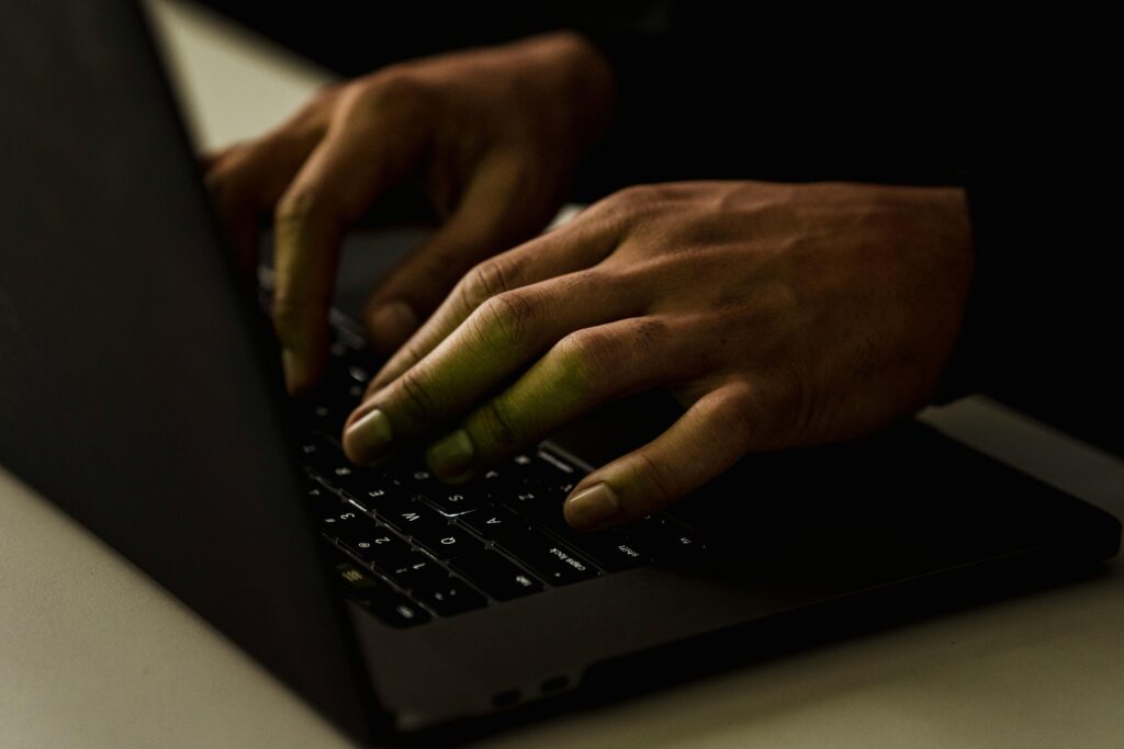 Close-up of a person typing on a laptop, representing the manual work involved in setting up Eloqua RSS email campaigns.